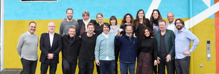 Snohetta, Nabil Gholam, Banque Libano-Française team, Daniel Berlin, Raya Raphael Nahhas, group photo of all 3 teams (17 persons) standing in front of a blue, yellow, orange and white background iin Oslo